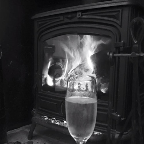 A glass of bubbly infront of the fire